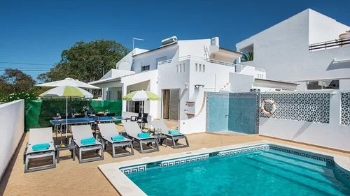 Private villa pool with sunloungers, parasols and an outdoor table tennis table