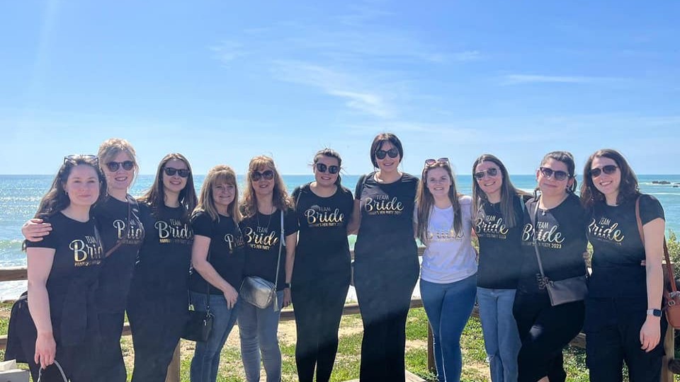 hen group smiling uin front of the sea