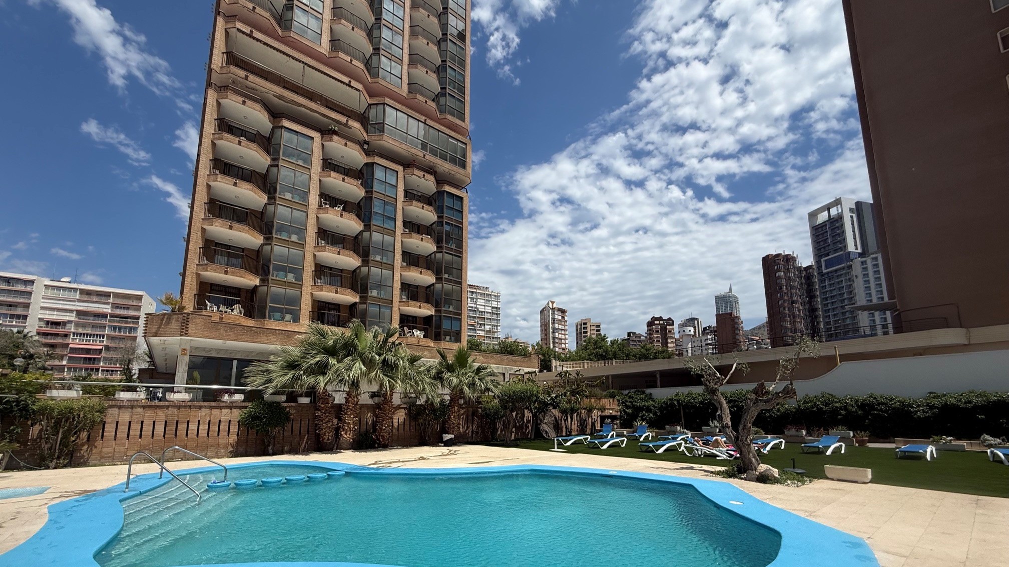 Outdoor swimming pool at Benidorm central apartments with sunbathing area