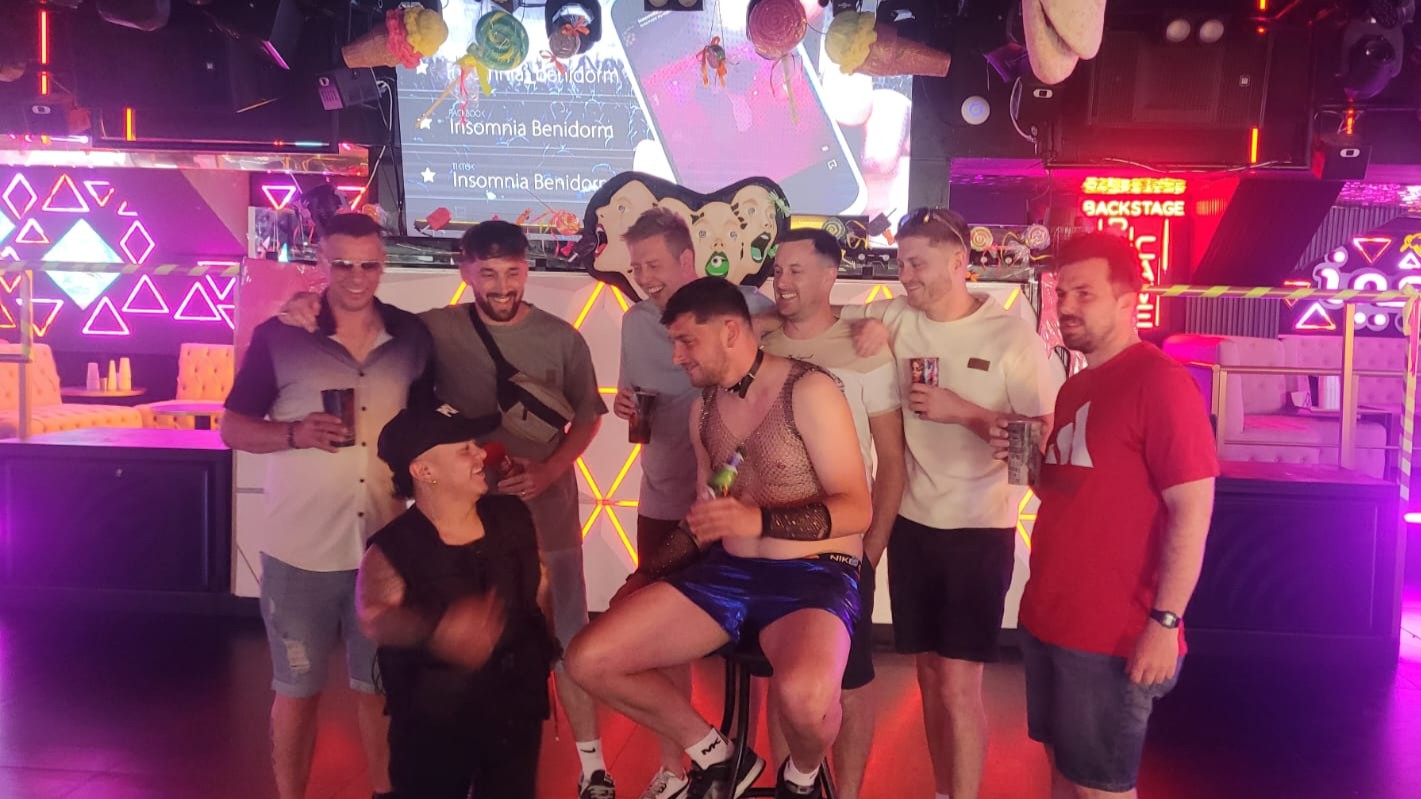 Stag group celebrating in Benidorm nightclub during dwarf handcuff prank