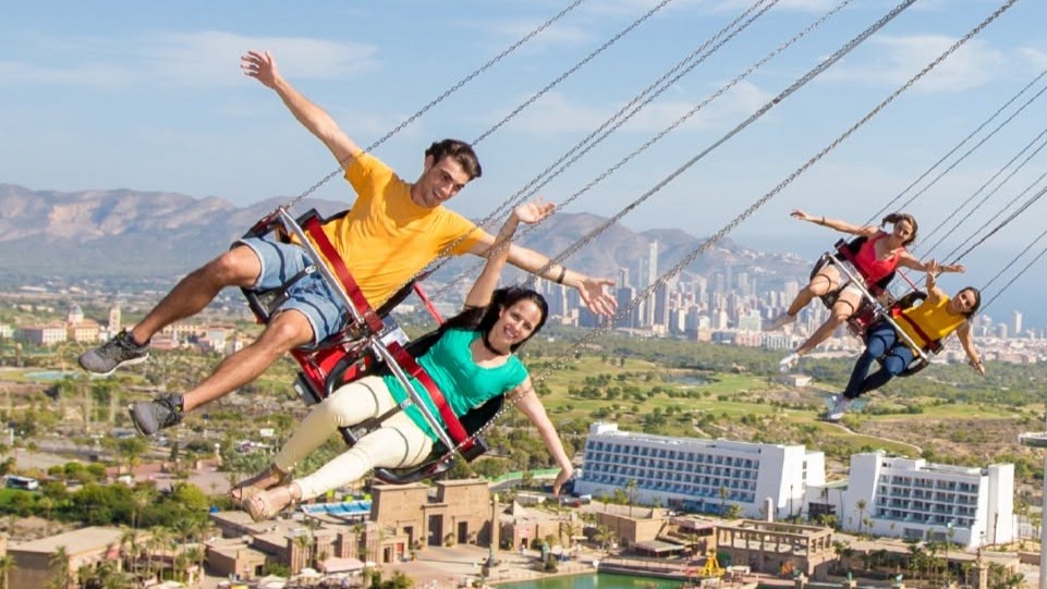 Riders on a high swing ride overlooking Benidorm at Terra M&iacute;tica