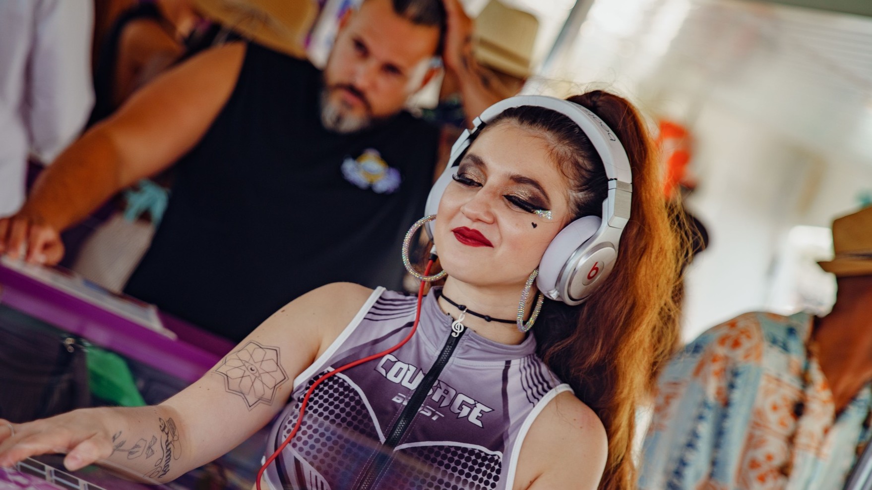 Female DJ playing music at a lively Benalmadena party boat event for stag and hen groups