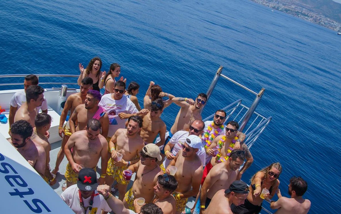 Stag group dancing and drinking on a party boat cruise in Benalmadena with sea views