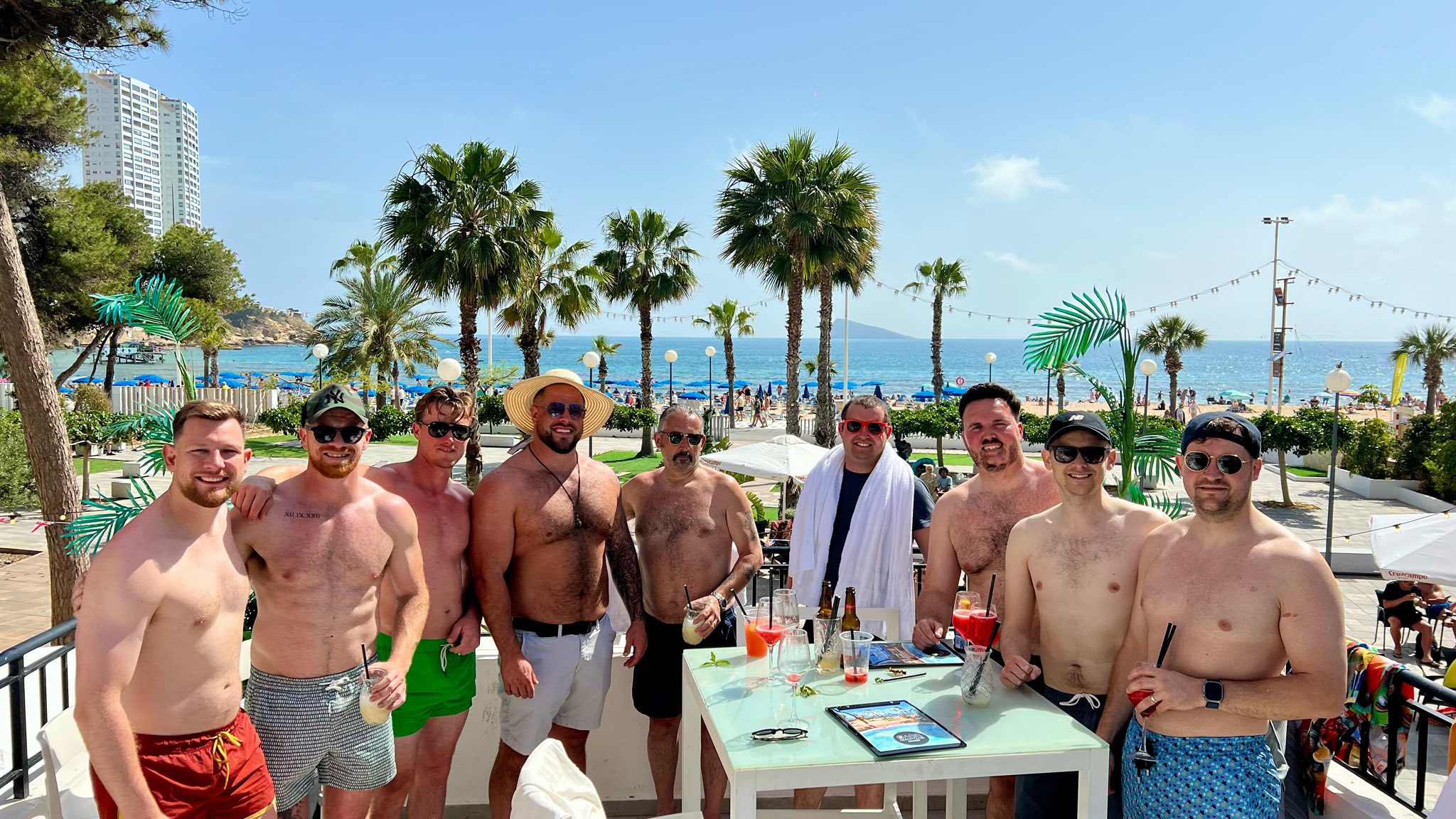colourfully dressed goup of men in front on the sea